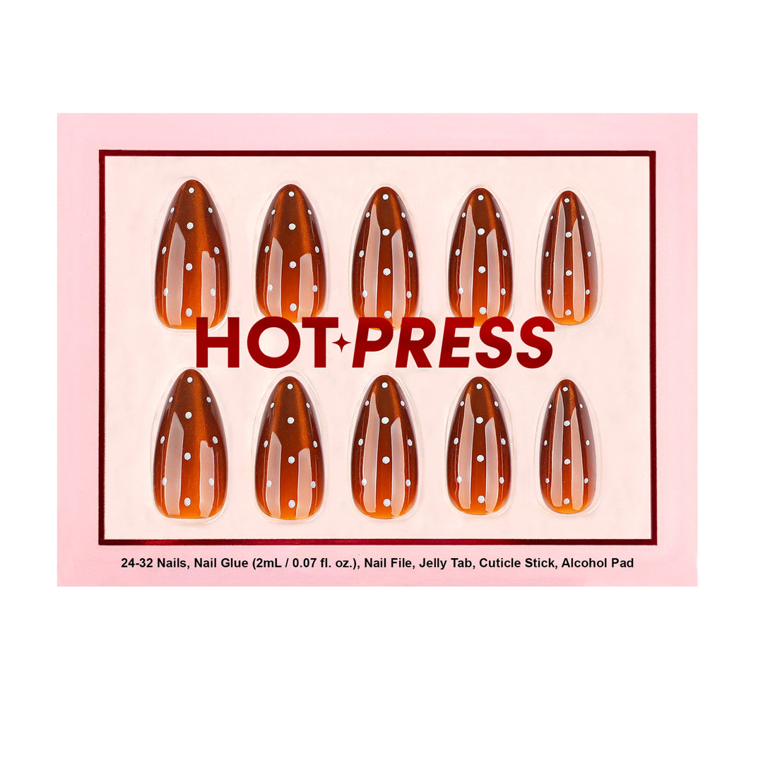 Almond-shaped press-on nails featuring a shimmering brown cat-eye magnetic effect and a vertical row of white polka dots.