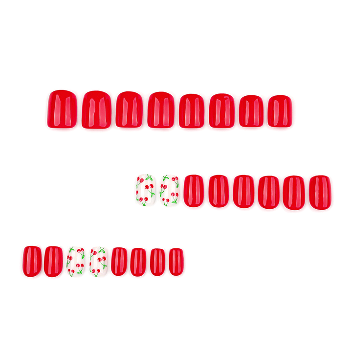 Short square-shaped press-on nails in a vibrant solid red. The set includes white accent nails featuring an all-over red cherry and green stem pattern.