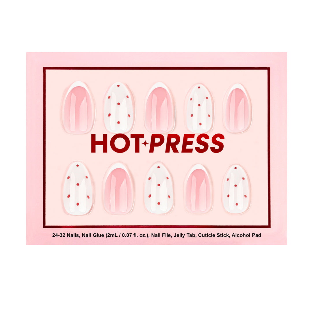 Almond press-on nails with pink French tips and white accent nails featuring red polka dots.