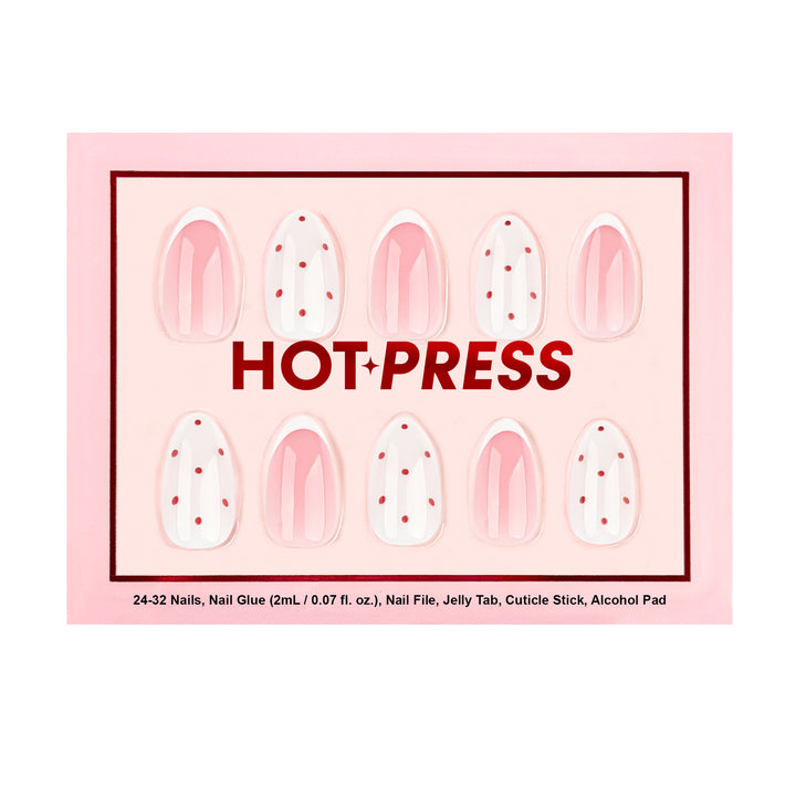 Almond press-on nails with pink French tips and white accent nails featuring red polka dots.