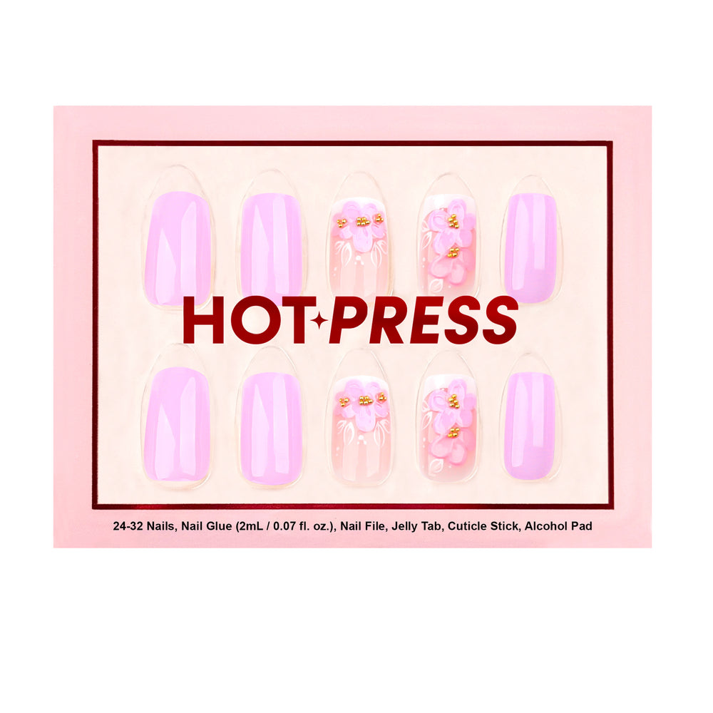 Medium almond press-on nails in a soft lavender-lilac glaze featuring raised 3D pink and purple floral art with gold beaded centers on a sheer gradient base.