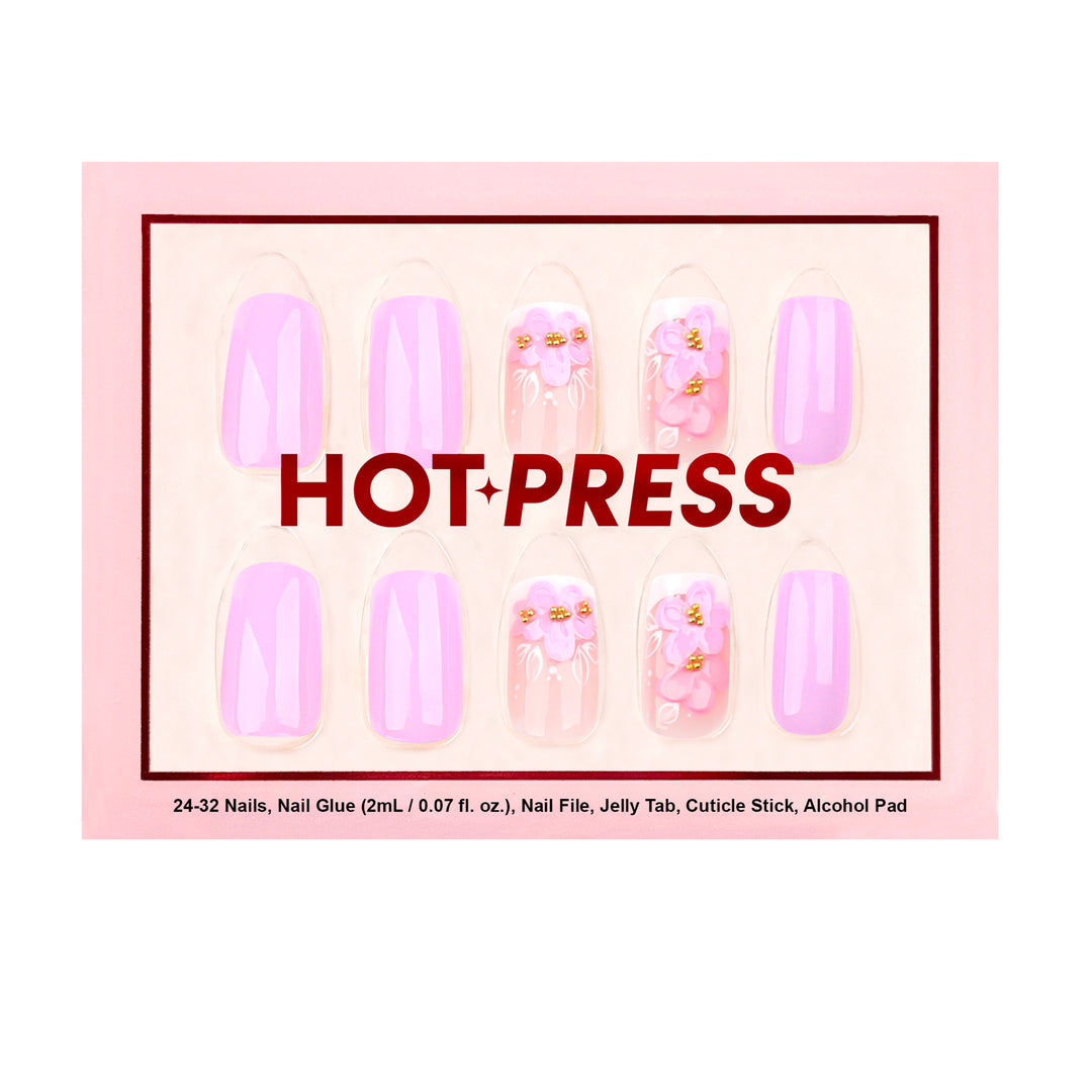 Medium almond press-on nails in a soft lavender-lilac glaze featuring raised 3D pink and purple floral art with gold beaded centers on a sheer gradient base.