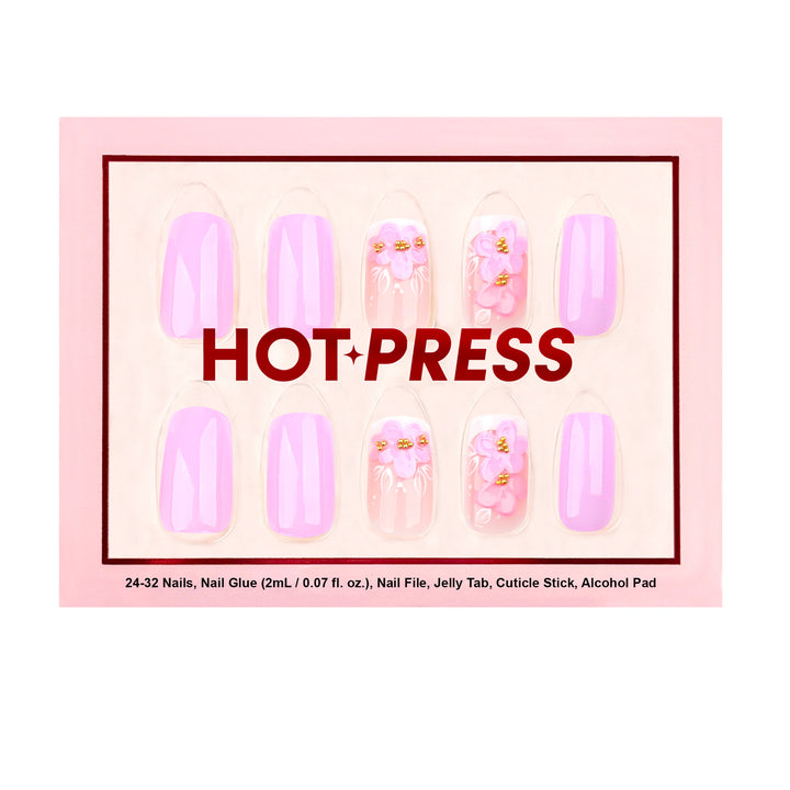 Medium almond press-on nails in a soft lavender-lilac glaze featuring raised 3D pink and purple floral art with gold beaded centers on a sheer gradient base.