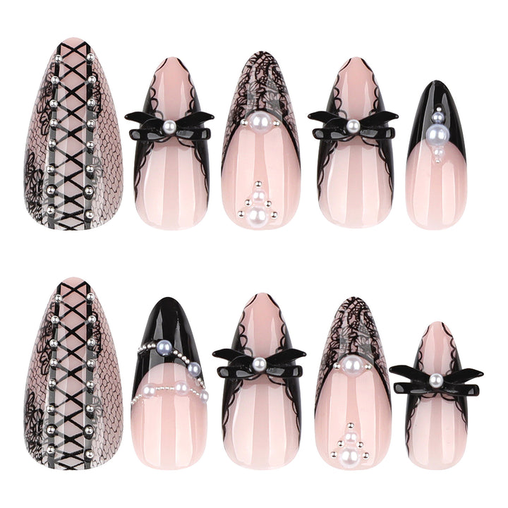 A display of ten press-on nails from the "Honey Moon" collection laid out in two rows against a white background. The nails feature a sheer, soft pink base in a medium almond shape, heavily detailed with an edgy, gothic bridal aesthetic including intricate black lace overlays, criss-cross corset lacing with tiny silver studs, 3D black bows centered with pearls, and delicate pearl strand accents.