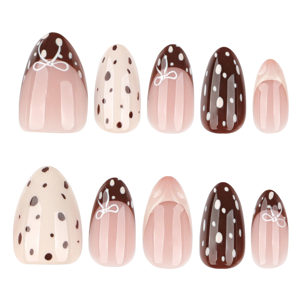 Almond-shaped press-on nails in brown and cream with polka dots, French tips, and small white bow designs.