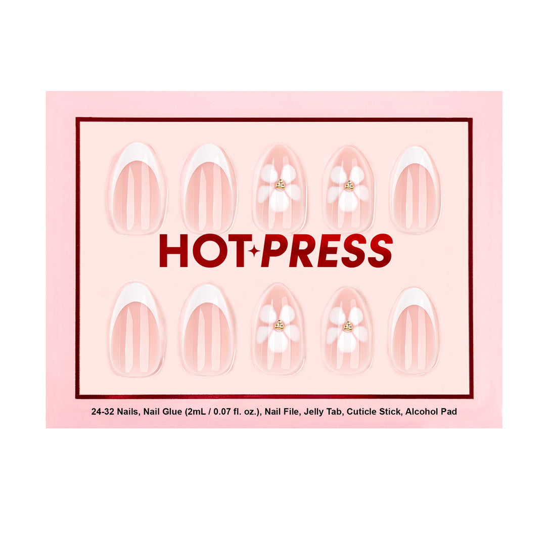 Medium almond press-on nails with a sheer base, crisp white French tips, and large white floral accents featuring 3D gold cluster gemstone centers.