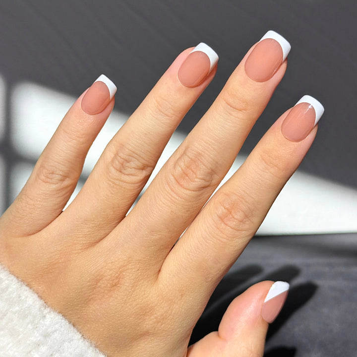 Rebel French long almond press-on nails featuring a high-gloss sheer nude base with abstract, organic liquid silver chrome swirls curving along the tips.