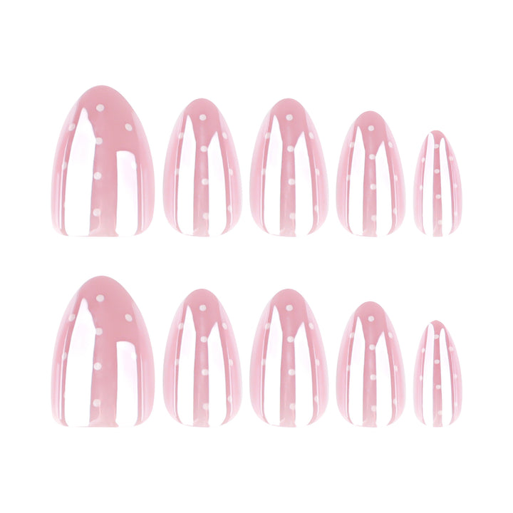 Almond shaped press-on nails featuring a soft baby pink base color and white polka dot accents.
