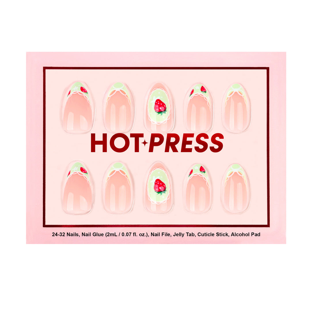 Light pink press-on nails with light green French tips, white lace patterns, and small red strawberry nail art. The middle nail features a single strawberry inside a white lace frame.