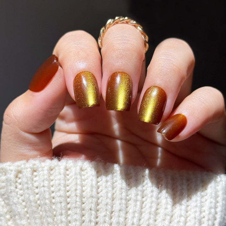 Brown Sugar short square press-on nails featuring a deep warm chocolate brown base topped with a brilliant gold velvet cat-eye magnetic flash reflection.