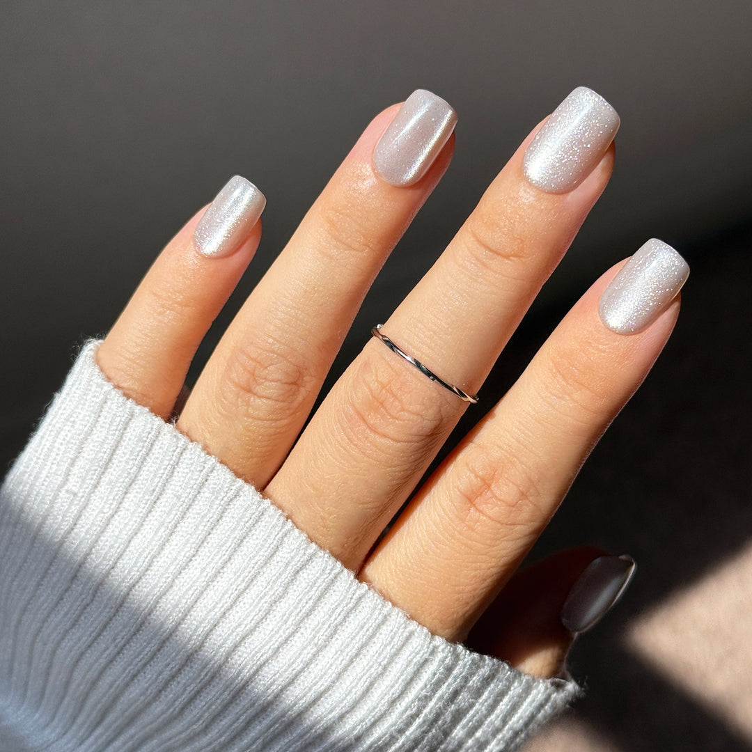 Icy It-Girl short square press-on nails featuring a sheer silver base topped with a highly reflective, liquid platinum velvet cat-eye magnetic flash shimmer.