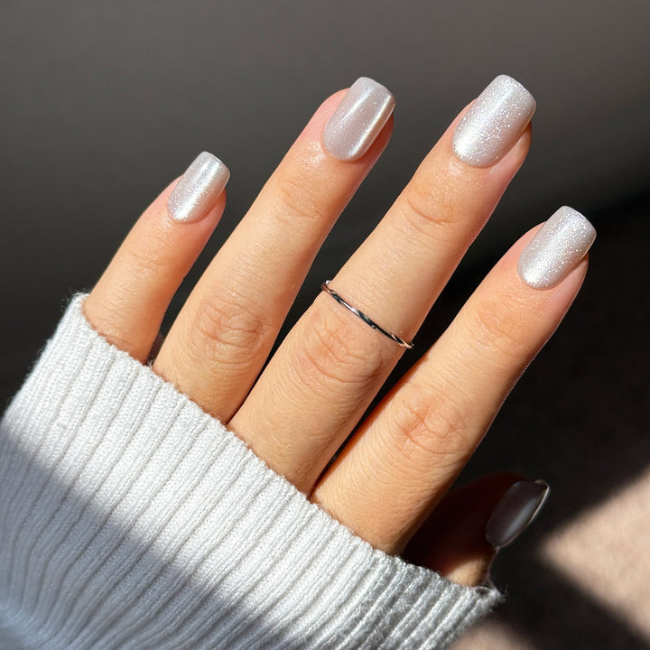 Icy It-Girl short square press-on nails featuring a sheer silver base topped with a highly reflective, liquid platinum velvet cat-eye magnetic flash shimmer.